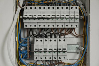 Işık duvarında birçok elektrik sayacı ve kablo olan sigorta kutusu, yakın plan.