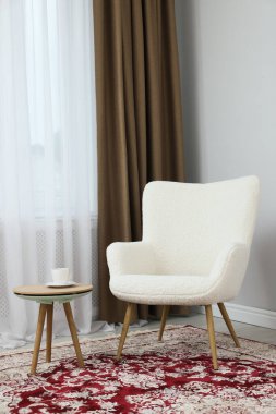 Yumuşak koltuk, sehpa ve odada perdeleri olan pencere. İç tasarım