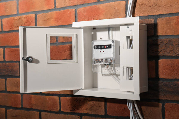 Электрометр в предохранителе на стене из красного кирпича. Прибор для измерения энергии