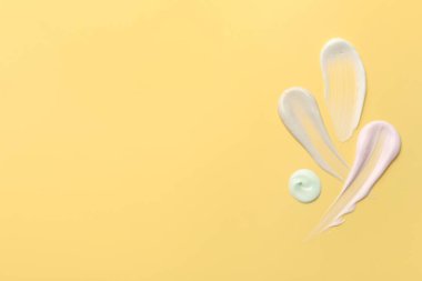 Sarı arka planda yüz kremi örnekleri, üst manzara. Metin için boşluk