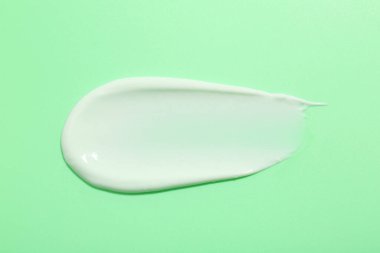 Yeşil arka planda yüz kremi örneği, üst görünüm