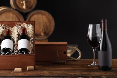 Ahşap kutular, cam ve şarap şişeleri karanlık arka planda.