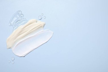 Açık mavi arka planda yüz kremi ve jöle, üst manzara. Metin için boşluk