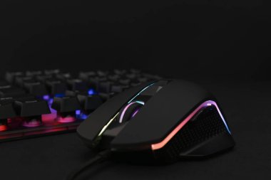 Siyah arkaplanda bilgisayar faresi ve RGB klavyesi, yakın plan