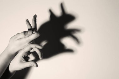 Gölge kuklası. Kadın arka plandaki tavşan gibi el hareketi yapıyor, mesaj için yeri olan bir yere yakın çekim yapıyor. Siyah ve beyaz etkisi