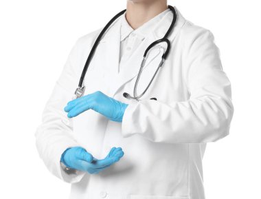 Doktor beyaz arka planda bir şey tutuyor, yakın plan.