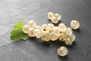 Gri desenli masada taze üzümler ve yeşil yaprak, yakın plan.