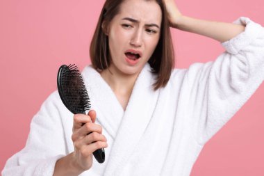 Pembe arka planda saçları dökülmüş, seçici odaklı duygusal bir kadın. Alopecia sorunu