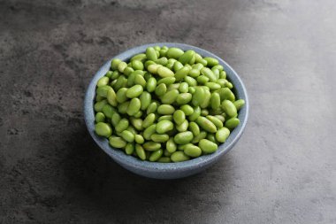 Çiğ yeşil edamame soya fasulyesi gri masada.