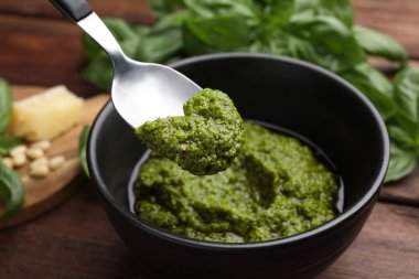 Ahşap masada lezzetli pesto sosu yiyorum, yakın plan.