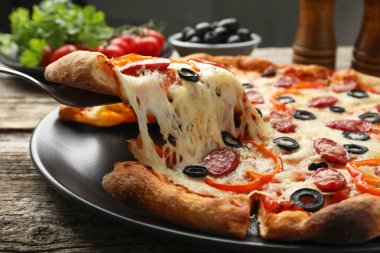Tahta masada lezzetli bir pizza yiyorum, yakın plan.
