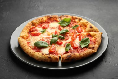 Siyah masada lezzetli bir Margherita pizza.