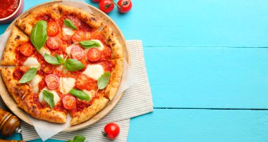 Lezzetli Margherita pizza ve açık mavi ahşap masa, üst manzara. Metin için boşluk