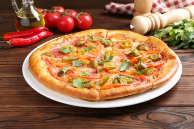 Lezzetli pizza Diablo ve ahşap masadaki malzemeler