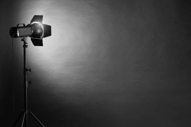 Karanlık fotoğraf arkaplanı ve profesyonel ışıklandırma ekipmanları stüdyoda. Metin için boşluk