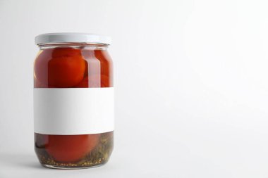 Hafif arka planda kavanozda lezzetli domates turşusu. Metin için boşluk