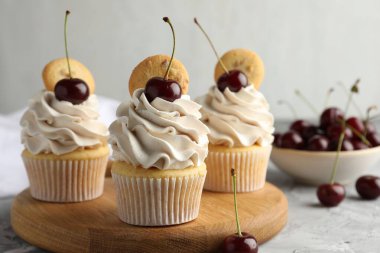 Gri masada vişneli ve kurabiyeli enfes kekler, yakın plan.