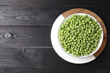 Siyah ahşap masada taze bezelyeler, üst manzara. Metin için boşluk