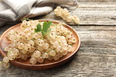 Taze kuşüzümü ve yeşil yaprak ahşap masada, yakın plan.