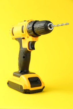 Sarı zemin üzerinde modern kablosuz elektrik matkabı