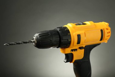 Gri arka planda modern kablosuz elektrikli matkap, yakın plan