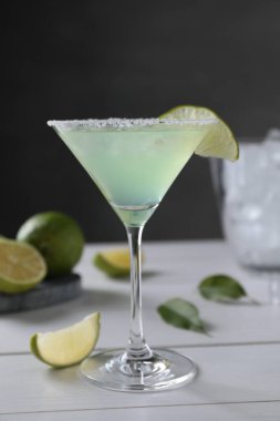 Lezzetli Margarita kokteyli ve beyaz ahşap masada limon.