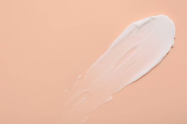 Mercan arka planda yüz kremi örneği, üst manzara. Metin için boşluk