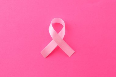 Pembe arka planda farkındalık kurdelesi, üst görünüm