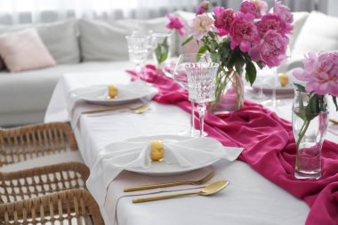 Beautiful table setting with pink peonies in dining room