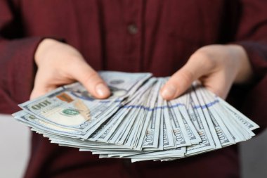 Kadın arka planda dolar banknotları sayıyor, yakın plan