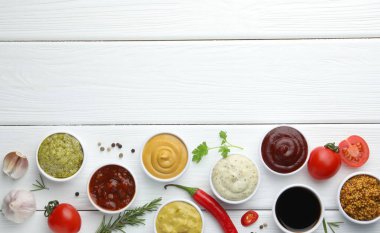 Birçok farklı sos, baharat ve sebze beyaz ahşap masa, düz yatak. Metin için boşluk
