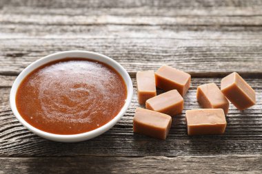 Kasede tuzlu karamel sosu ve ahşap masada lezzetli şekerler.