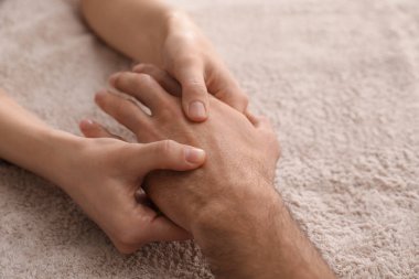 Yumuşak havluya el masajı yaptıran adam, yakın plan.