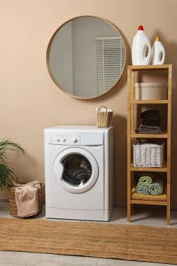 Çamaşır odasının içini çamaşır makinesi, mobilya ve sepetlerle süsleyin.