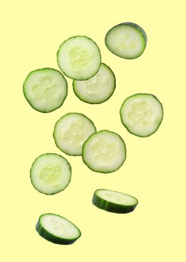 Sarı arka planda taze salatalık dilimleri