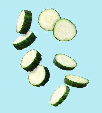 Açık mavi arka planda taze salatalık dilimleri