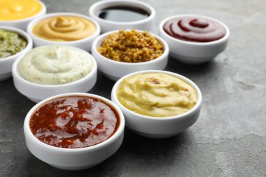 Gri masadaki kaselerde farklı soslar, yakın plan.