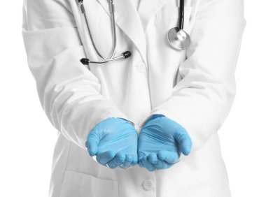 Doktor beyaz arka planda bir şey tutuyor, yakın plan.