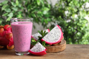 Lezzetli pitahaya smoothie ve ahşap masada taze meyve, metin için yer