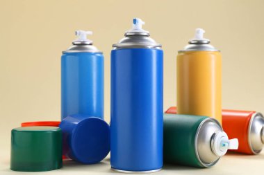 Bej arka planda birçok sprey boya kutusu