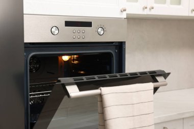 Mutfakta havluyla elektrikli fırını aç. Yemek pişirme aygıtı