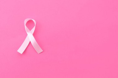 Pembe arka planda farkındalık kurdelesi, üst manzara. Metin için boşluk