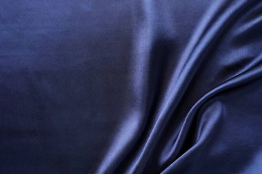 Arka plan olarak buruşmuş koyu mavi ipek kumaş, üst manzara. Metin için boşluk