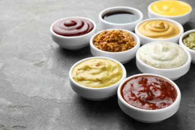 Gri masadaki kaselerde farklı soslar var. Yakın plan. Metin için boşluk