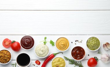 Birçok farklı sos, baharat ve sebze beyaz ahşap masa, düz yatak. Metin için boşluk