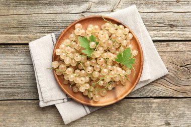 Taze üzümlü üzümler ve yeşil yapraklar ahşap masada, üst tarafta.