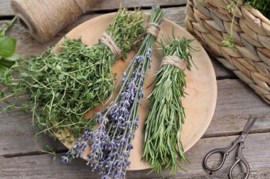 Ahşap masada değişik aromatik otlar ve makas.
