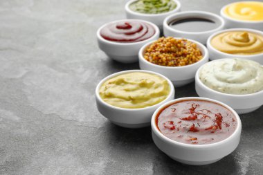 Gri masadaki kaselerde farklı soslar var. Yakın plan. Metin için boşluk