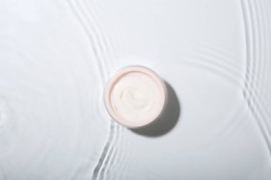 Kozmetik ürünü. Hafif arka planda kremalı kavanoz, üst görünüm