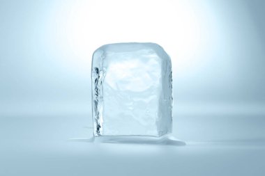 Cube of clear ice on light blue background clipart